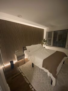 Wooden slat accent wall installation in modern bedroom by Flash Handy