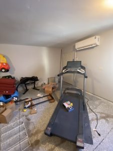 Garage gym setup with wall-mounted fitness equipment and treadmill by Flash Handy