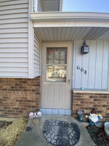 Old beige aluminum storm door with wear and fading before replacement – Flash Handy