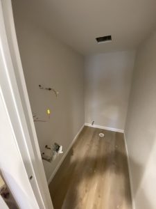 Modern bathroom with LED round mirror, white vanity, and new vinyl flooring installed by Flash Handy