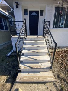 Worn and weathered front porch wood stairs with peeling paint and exposed grain